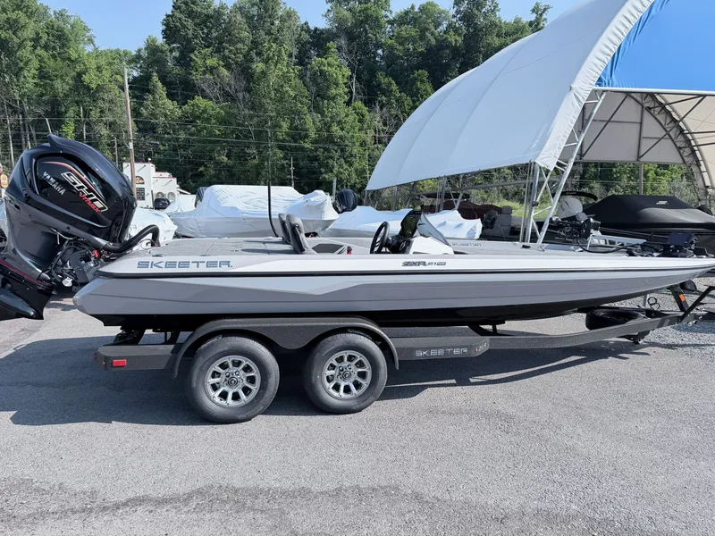 The Image of A gray Skeeter ZXR20 SE boat from 2026 is on a trailer in a parking lot. - 1