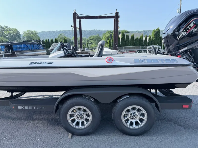 Slide: The Image of A gray Skeeter ZXR20 SE boat on a trailer, featuring a powerful outboard motor. - 24