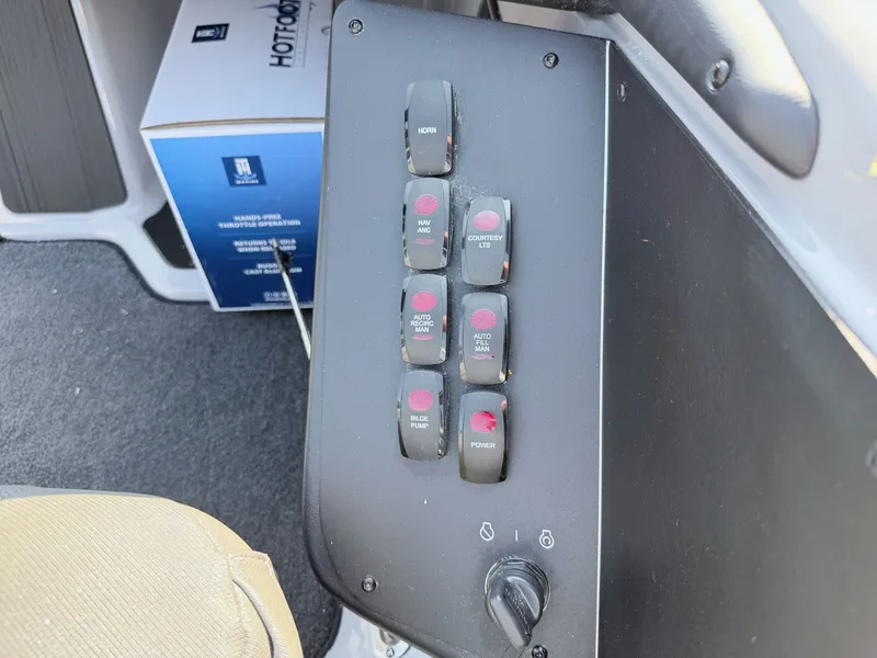 Slide: The Image of Control panel with multiple switches and a dial, inside a boat. - 13