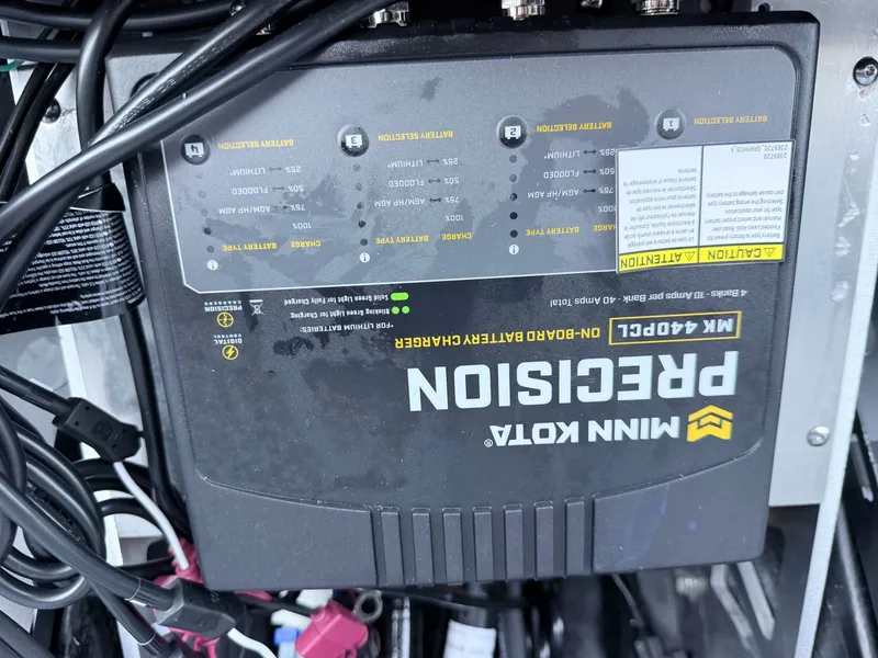 Slide: The Image of A Minn Kota Precision battery charger is installed in a boat, surrounded by cables. - 27