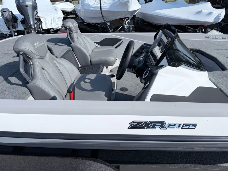Slide: The Image of The image shows the cockpit of a Skeeter ZXR20 SE boat with gray seats and a helm. - 22