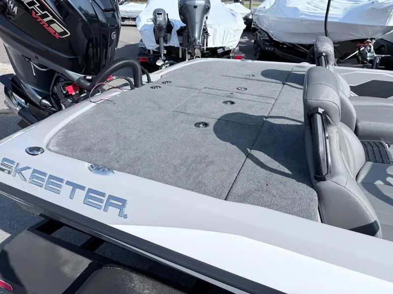 Slide: The Image of The image shows the deck of a Skeeter ZXR20 SE boat with gray carpeting. - 32