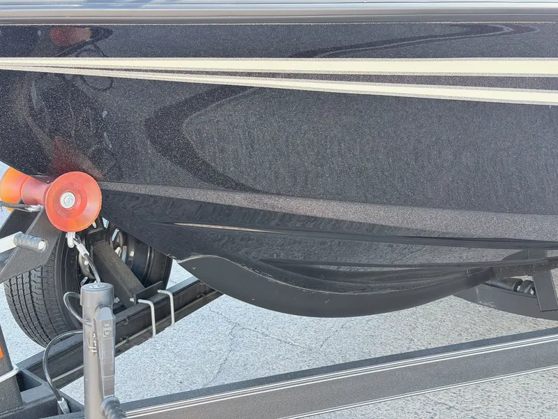 Slide: The Image of Close-up of a black boat hull with stripes, on a trailer. - 4