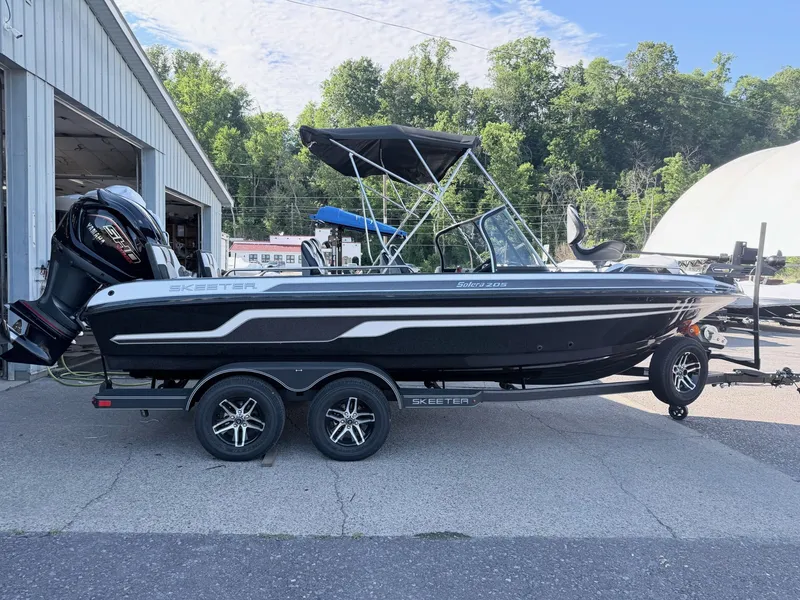 The Image of A 2025 Skeeter Solera 205 boat on a trailer in front of a building. - 1