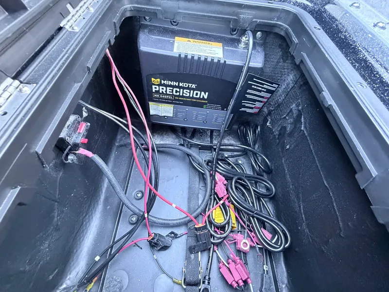 Slide: The Image of A Minn Kota Precision charger in a boat storage compartment with cables and connectors. - 7