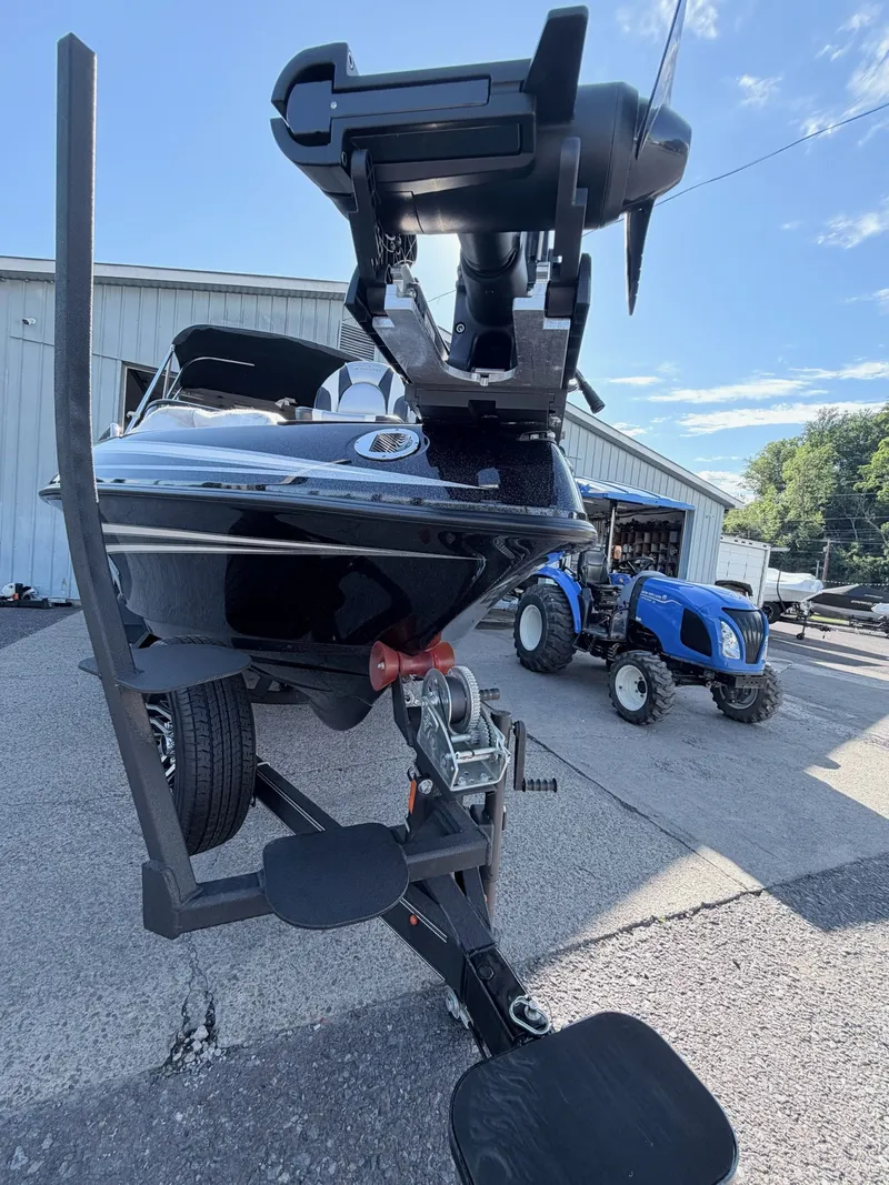 Slide: The Image of A Skeeter Solera 205 boat on a trailer, with a tractor in the background. - 2