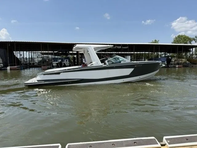 Slide: The Image of A 2021 Aviara AV32 boat cruising on calm water, surrounded by a marina. - 11