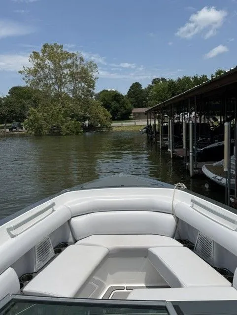 Slide: The Image of The image shows the bow of a 2021 Aviara AV32 boat on calm water near a dock. - 23