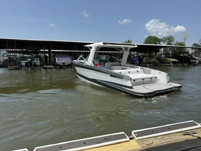 Slide: The Image of A 2021 Aviara AV32 cruising on calm water near a covered dock. - 5