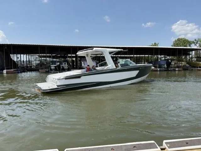 Slide: The Image of A 2021 Aviara AV32 boat cruising on calm water in a marina. - 8