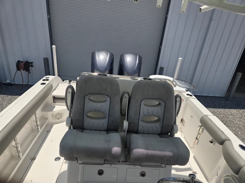 Slide: The Image of Two gray seats on a boat, with engines in the background, in front of a building. - 9