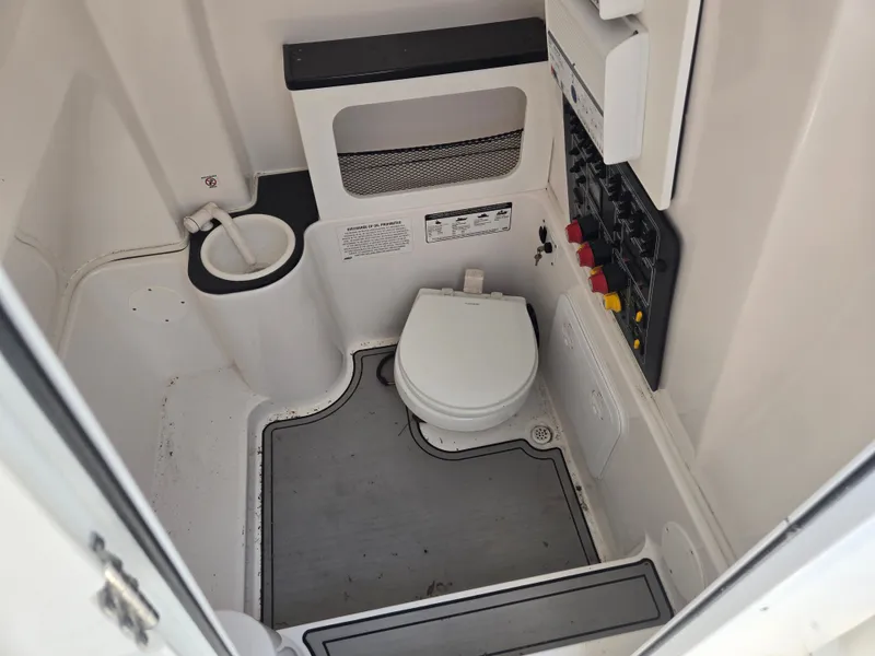 Slide: The Image of Interior view of a boat toilet with a gray floor and white walls. - 16