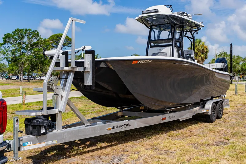 Slide: The Image of 2021 Costa Custom Boats 264HC on trailer, parked outdoors under a blue sky. - 4