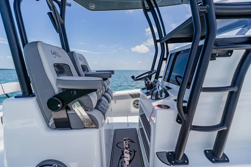 Slide: The Image of 2021 Costa Custom Boats 264HC interior with helm and seating, ocean backdrop. - 67