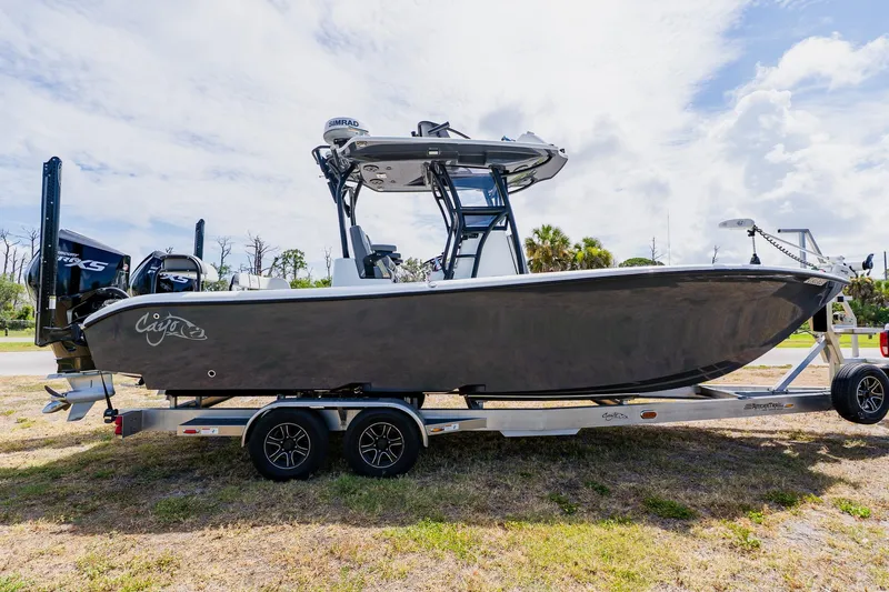 Slide: The Image of 2021 Costa Custom Boats 264HC on trailer, sleek design, parked outdoors under cloudy sky. - 7