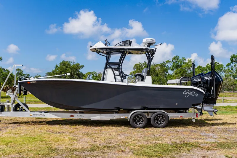 Slide: The Image of 2021 Costa Custom Boats 264HC on trailer, sleek design, parked outdoors under blue sky. - 0