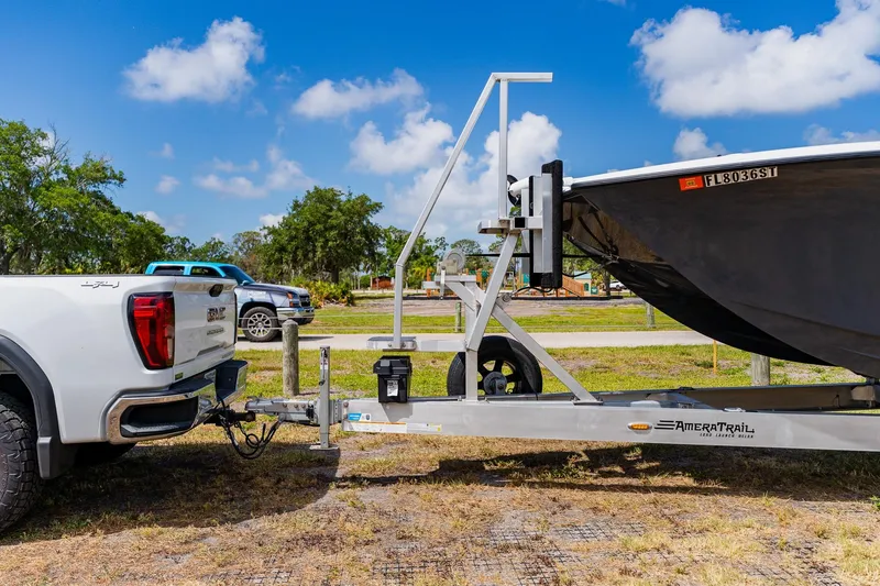 Slide: The Image of White truck towing a 2021 Costa Custom Boats 264HC on a trailer under a clear blue sky. - 5