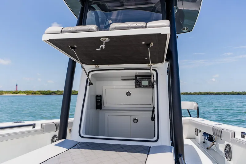 Slide: The Image of 2021 Costa Custom Boats 264HC interior with storage and control panel, on a sunny day at sea. - 54