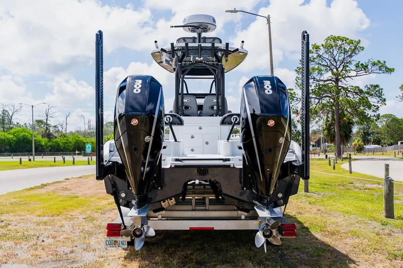 Slide: The Image of 2021 Costa Custom Boats 264HC with dual outboard engines, parked on a sunny day. - 2