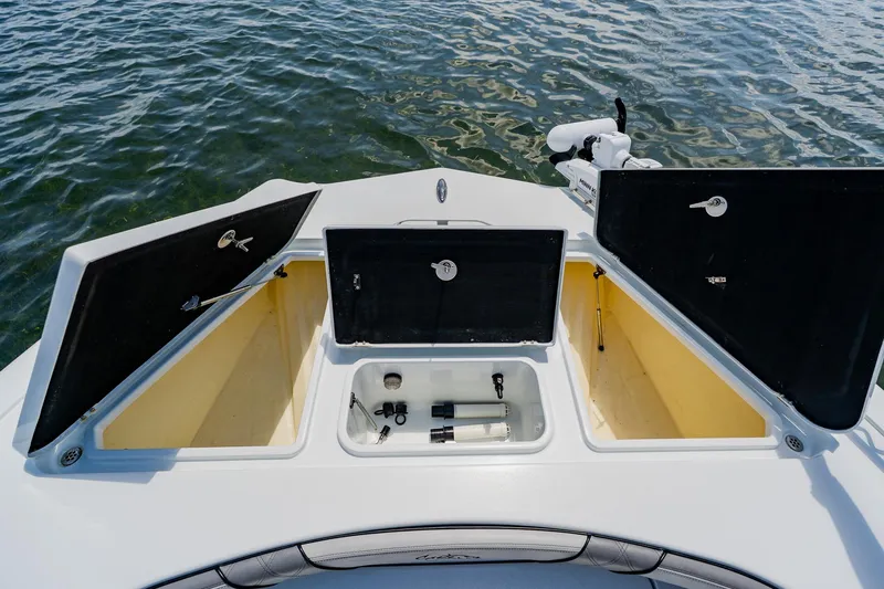 Slide: The Image of 2021 Costa Custom Boats 264HC storage compartments open on calm water. - 31