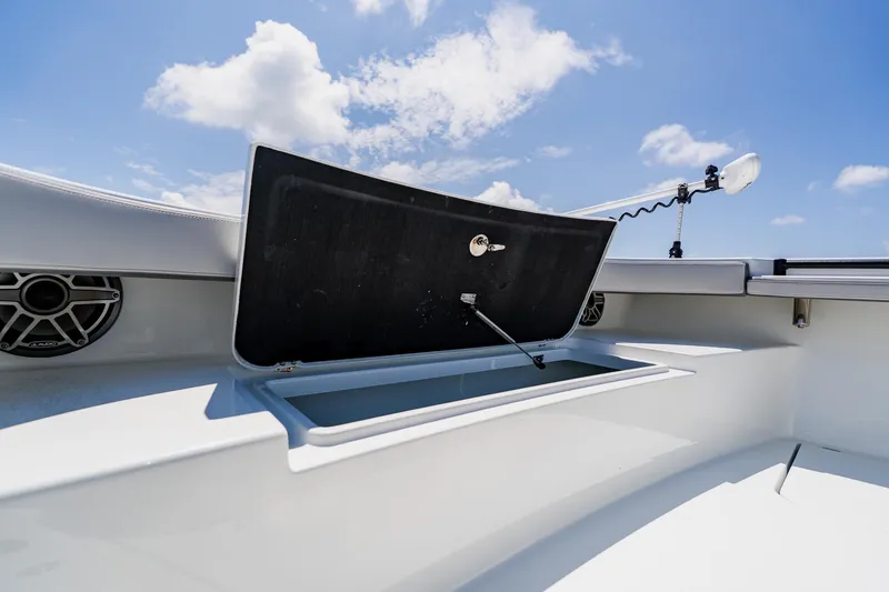 Slide: The Image of 2021 Costa Custom Boats 264HC storage compartment open under clear blue sky. - 38