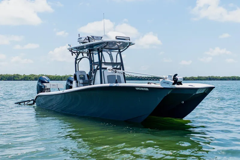 Slide: The Image of 2021 Costa Custom Boats 264HC on calm water, showcasing sleek design and dual engines. - 14