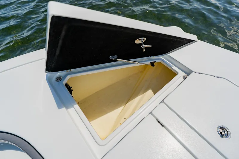 Slide: The Image of Open storage compartment on 2021 Costa Custom Boats 264HC, with key lock, near water. - 34