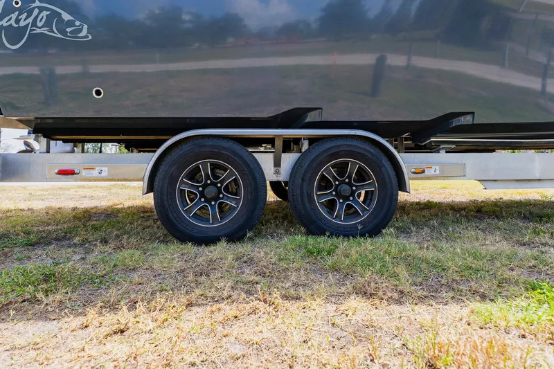 Slide: The Image of Trailer wheels of a 2021 Costa Custom Boats 264HC on grass. - 8