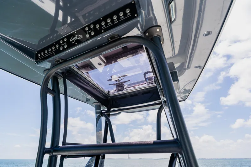 Slide: The Image of Costa Custom Boats 264HC 2021 model, featuring sleek design and advanced controls under a clear sky. - 76