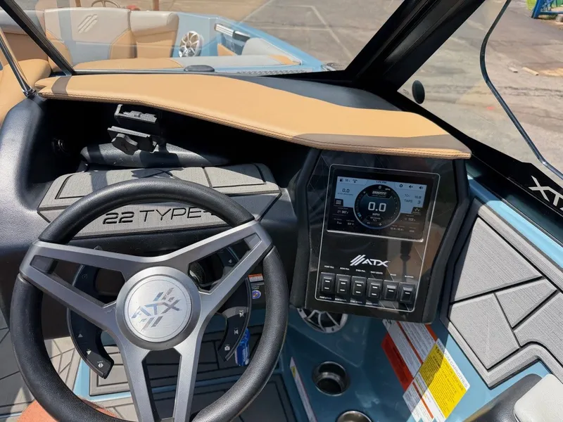 Slide: The Image of The image shows the cockpit of a 2021 ATX 22 Type-S boat with a modern steering wheel and display. - 19