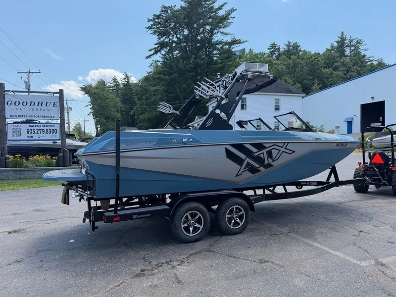 The Image of ATX 22 Type-S boat from 2021 on a trailer, surrounded by buildings and trees. - 1