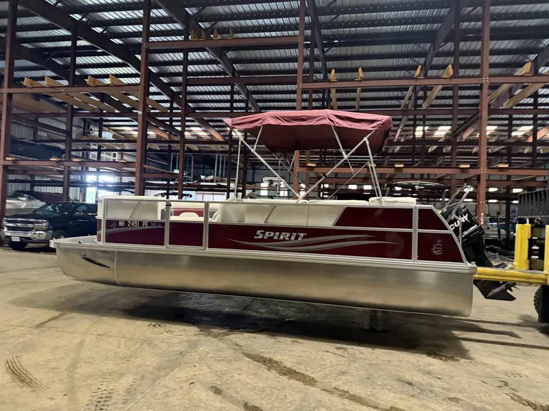 Slide: The Image of A red pontoon boat with a canopy is in a warehouse. - 15