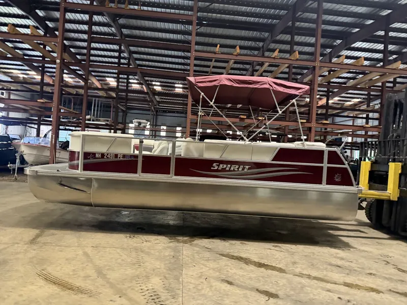 Slide: The Image of 2011 JC Spirit pontoon boat in warehouse with red sunshade. - 10
