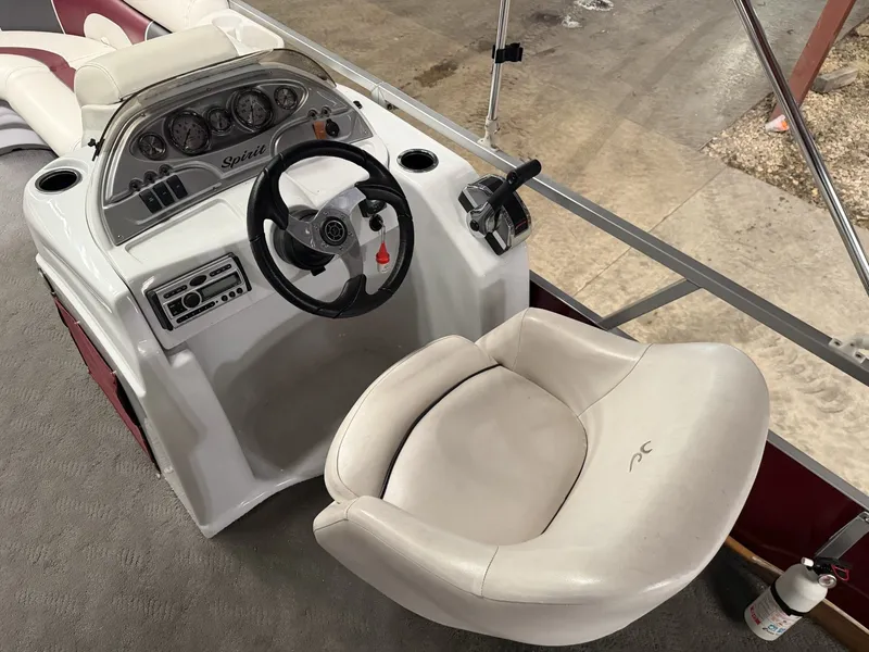 Slide: The Image of Helm of a 2011 JC Spirit boat with white seat and dashboard. - 3