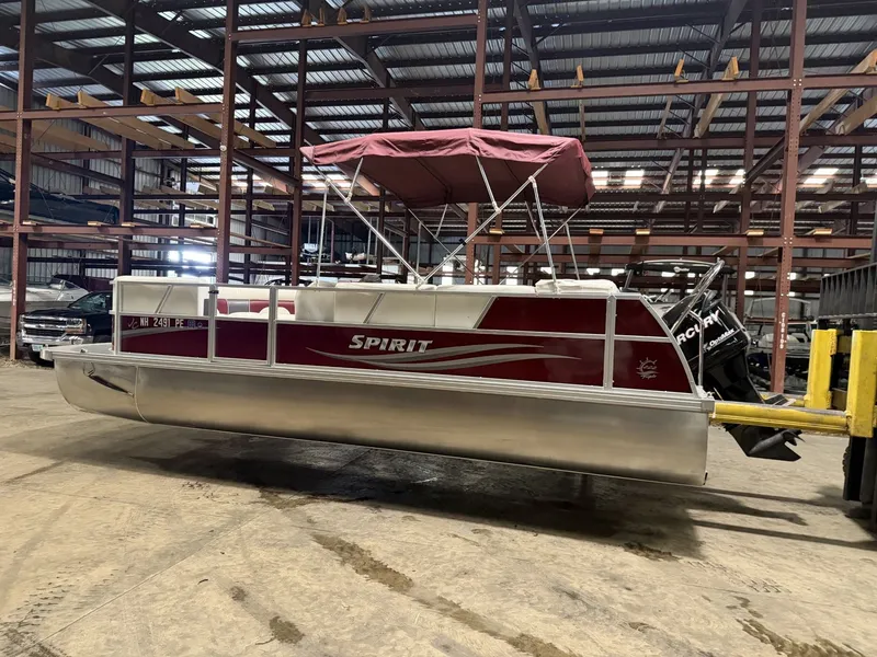 Slide: The Image of A red pontoon boat with a sunshade is in a warehouse. - 11