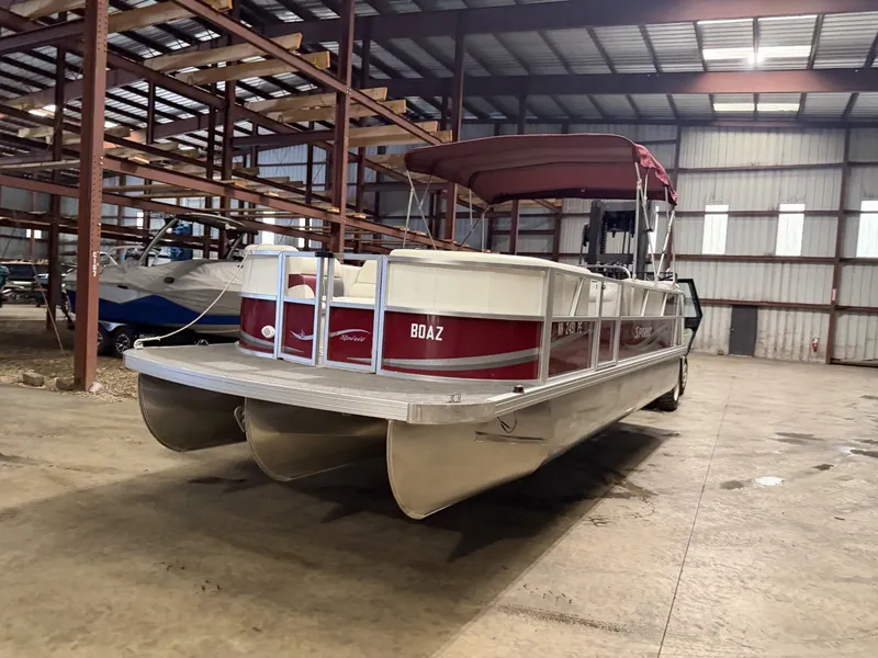 Slide: The Image of A red pontoon boat with a canopy is stored in a warehouse. - 5
