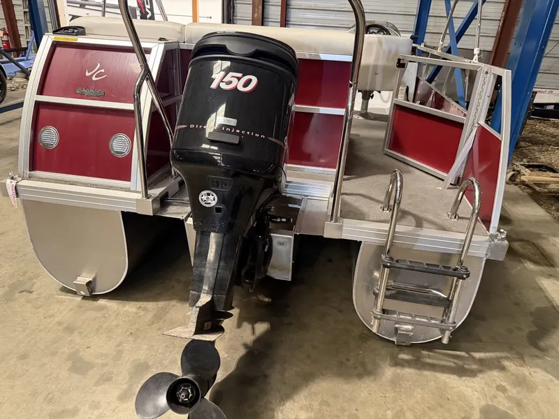 Slide: The Image of Red pontoon boat with an outboard motor in a storage facility. - 12