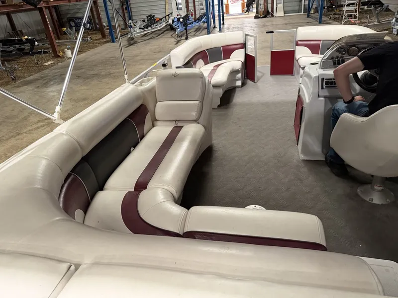 Slide: The Image of Interior of a 2011 JC Spirit pontoon boat with white and red seating. - 2