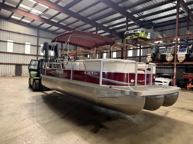 Slide: The Image of A red pontoon boat with a canopy is in a warehouse. - 7