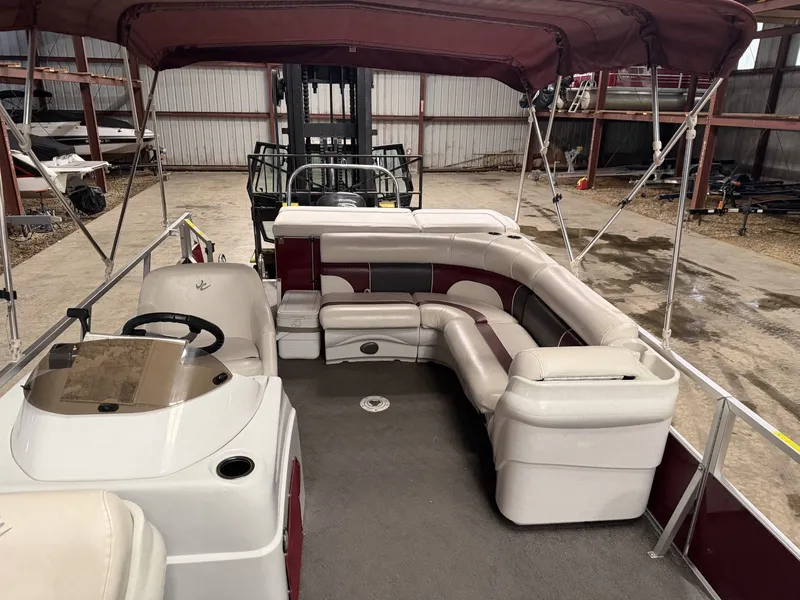 Slide: The Image of The image shows the interior of a 2011 JC Spirit pontoon boat with seating and a helm. - 8