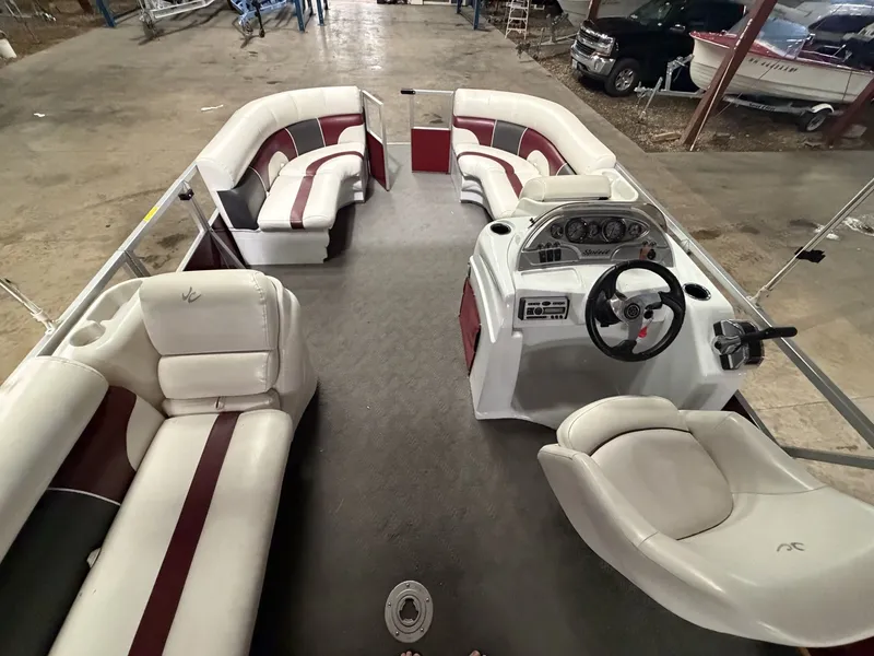 Slide: The Image of Interior of a 2011 JC Spirit pontoon boat with white and red seating. - 14