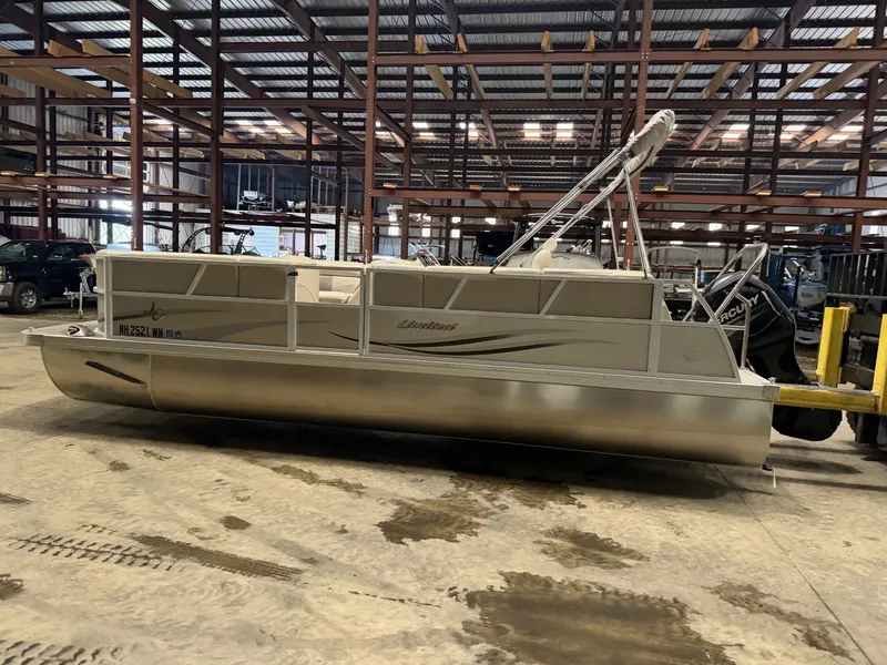 Slide: The Image of A pontoon boat is parked in a warehouse on a concrete floor. - 26