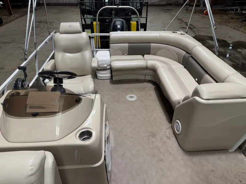 Slide: The Image of Interior of a 2013 JC pontoon boat with beige leather seating and a helm station. - 9