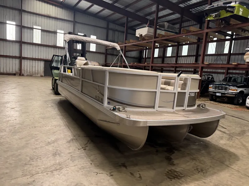 Slide: The Image of A pontoon boat is in a warehouse, surrounded by other vehicles and shelves. - 2