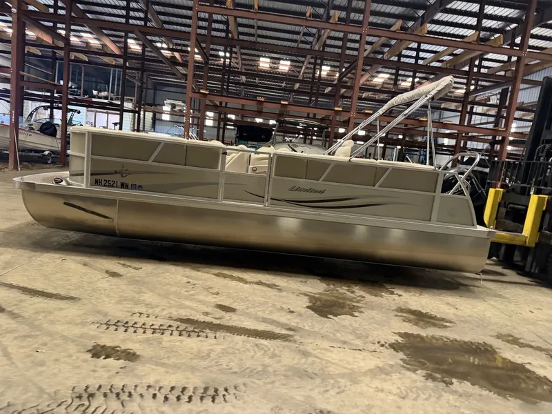Slide: The Image of A pontoon boat is parked in a warehouse on a concrete floor. - 6