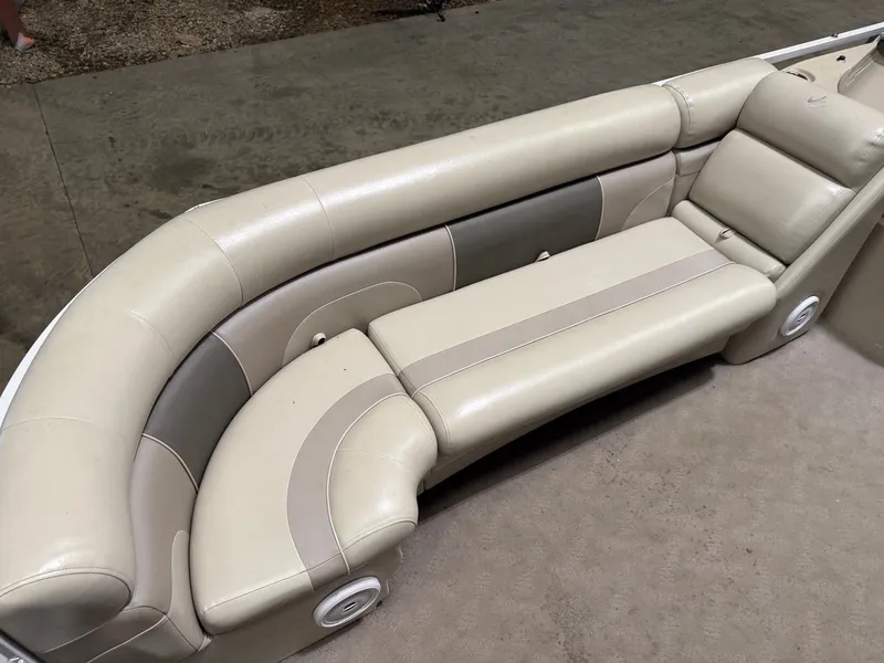 Slide: The Image of A cream-colored upholstered seating area in a boat with rounded corners and speakers. - 8