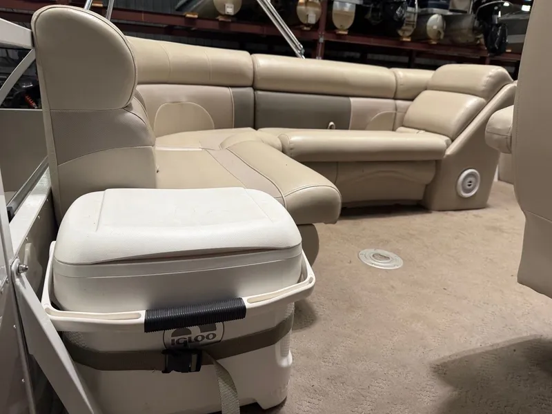 Slide: The Image of Interior of a pontoon boat with beige leather seating and an Igloo cooler. - 25