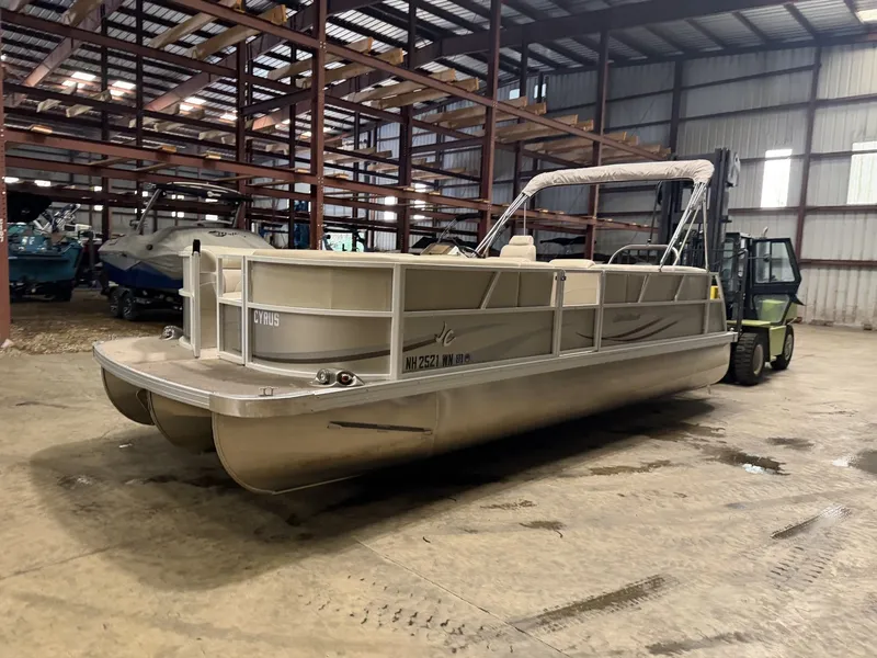 Slide: The Image of A pontoon boat is in a warehouse, surrounded by other boats and a forklift. - 22