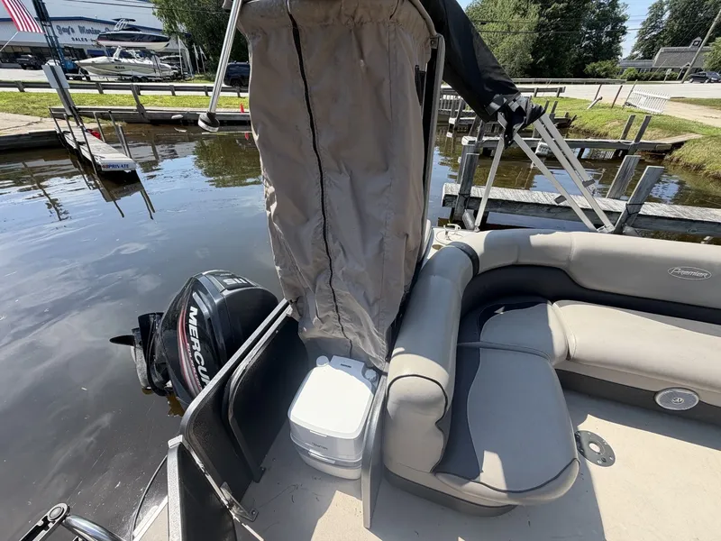 Slide: The Image of A 2014 Premier 240 SunSation pontoon boat at the dock with gray seating and a Mercury engine. - 11