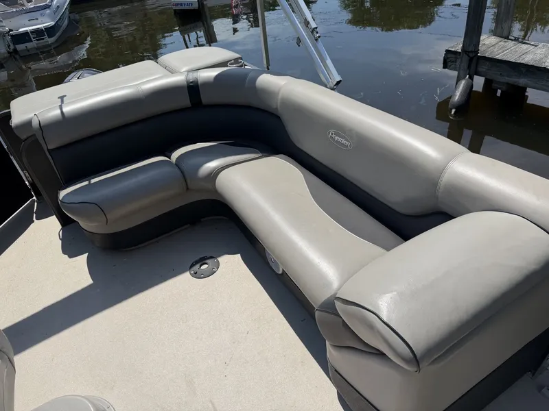 Slide: The Image of Gray cushioned seating on a boat, with water and a dock in the background. - 10